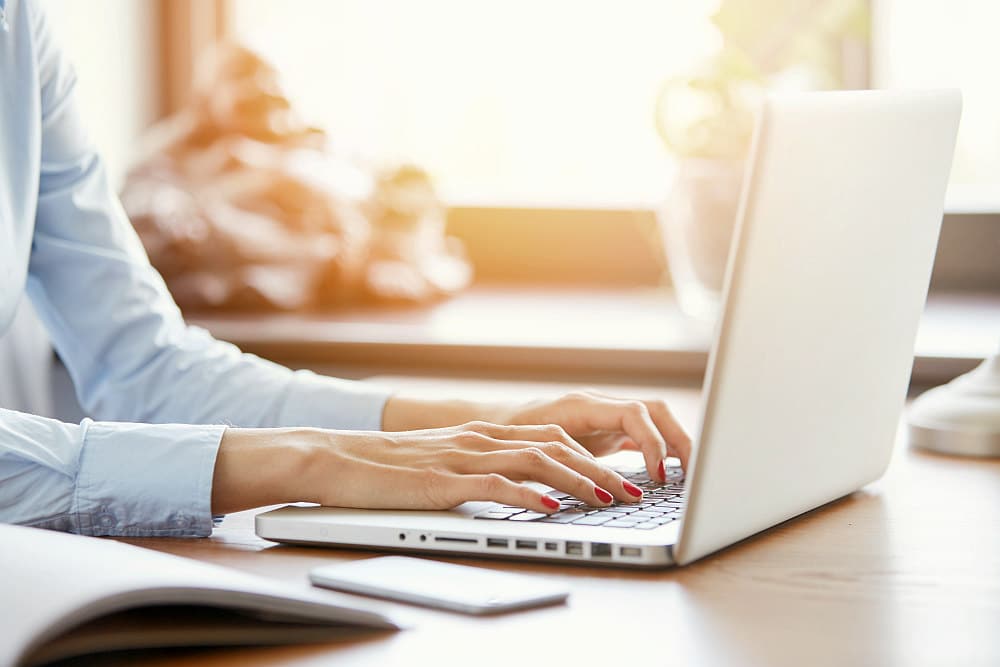 Woman's hands with red nails typing on keyboard | Why Email Marketing Is Important For Bookkeeping Firms | how to email marketing