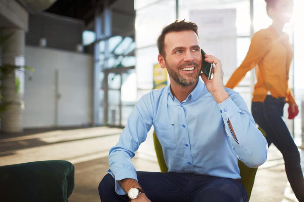 Handsome businessman talking on the phone during coffee break in a cafe | Fail-Proof Networking Strategies For Bookkeepers | effective networking strategies