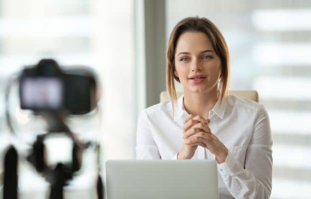 a woman sitting in front of the camera recording ca