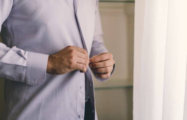 A man gets dressed before work | Don’t Work Casual | Work From Anywhere In The World By Following These 9 Tips