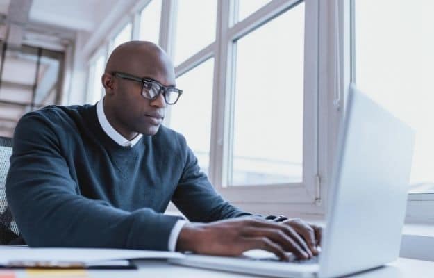 Image of african american businessman working on his laptop ss