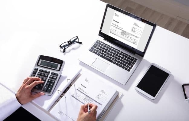 a laptop, calculator and tape of document on the white table | July 10, 2020 - Employees Who Receive Tips | Important Fiscal Dates for H2 2020