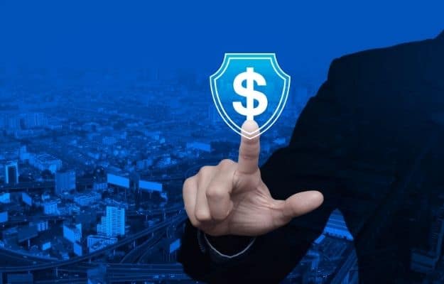 a business man is pointing at the money logo inside the shield | 6 Tips To Finance A Small Business | Get Business Insurance