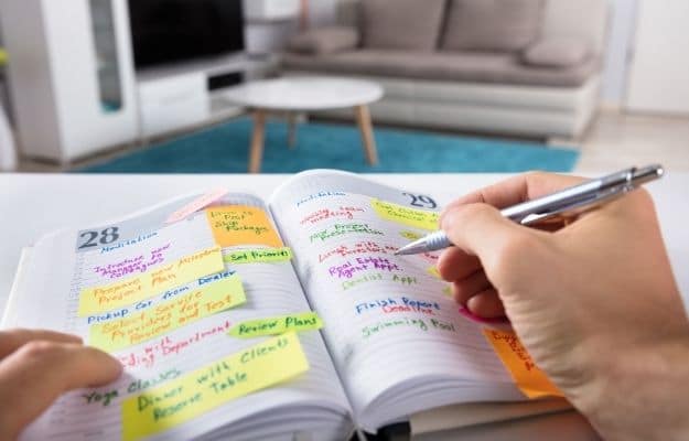 a schedule book and a hand holding pen ca