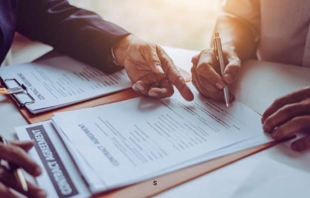 two people are looking at the contract paper | Consider Franchising Rights | How-Much-Is-Your-Franchise-Actually-Worth