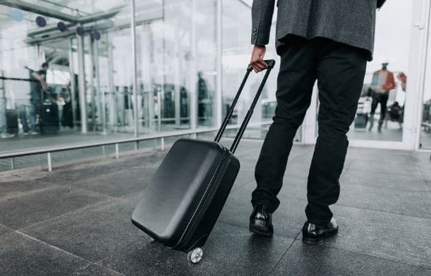 Close up of male in business suit is taking suitcase | What to Pack for a Bookkeeping Work Trip | Carry On Suitcase