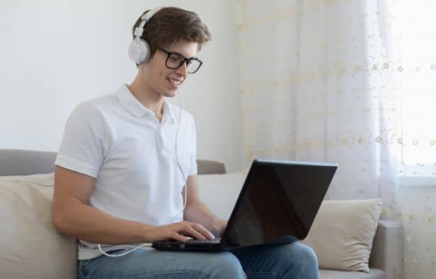 a man wearing headphone is working at home ca