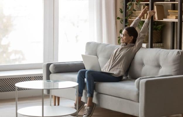 a woman is sitting on sofa and sketching hand ca