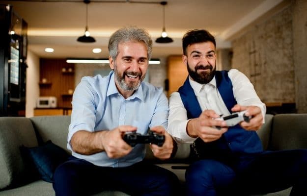 two men are happily playing video game ca